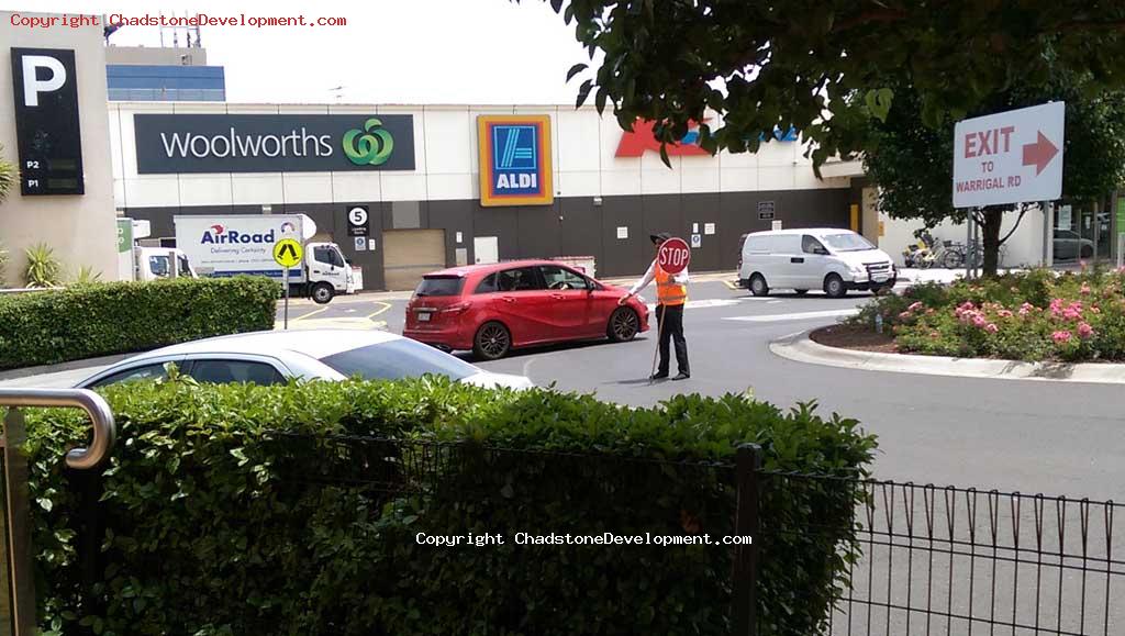 A traffic controller directs motorists at the Middle Rd roundabout - Chadstone Development Discussions